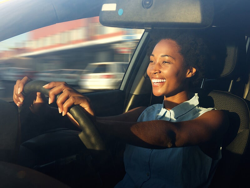 Happy woman driving her car