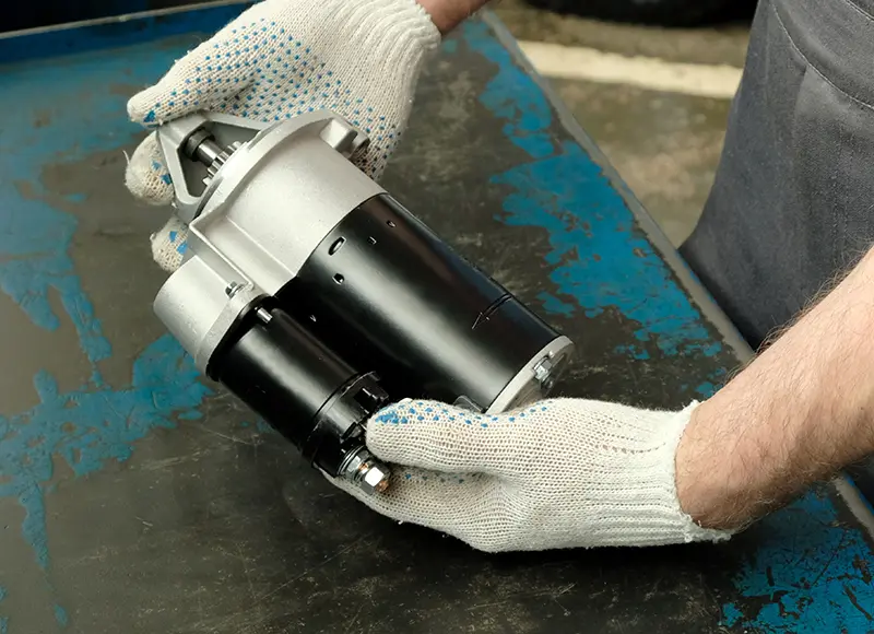 Technician holding engine start motor